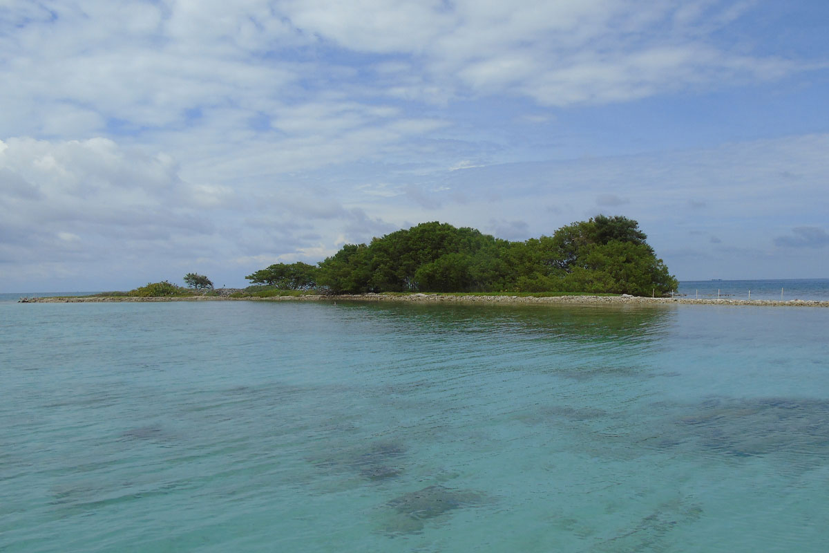 Best-time-to-visit-Belize A tranquil solitary island surrounded by turquoise waters under sunny skies in Belize — captured during the dry season, showcasing the best time to visit Belize.