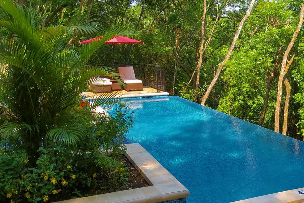 JungleLodge-SanIgnacio - Authentic Travel Belize Secluded swimming pool surrounded by lush tropical forest, part of Belize vacation packages for couples seeking jungle luxury and romantic escapes.