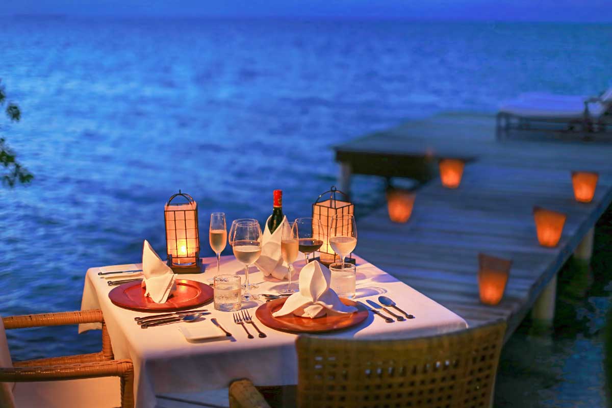 Romantic-Beach-dinner - Authentic Travel Belize Romantic beachside candlelit dinner at sunset, part of Belize vacation packages for couples seeking luxury, privacy, and unforgettable tropical moments.