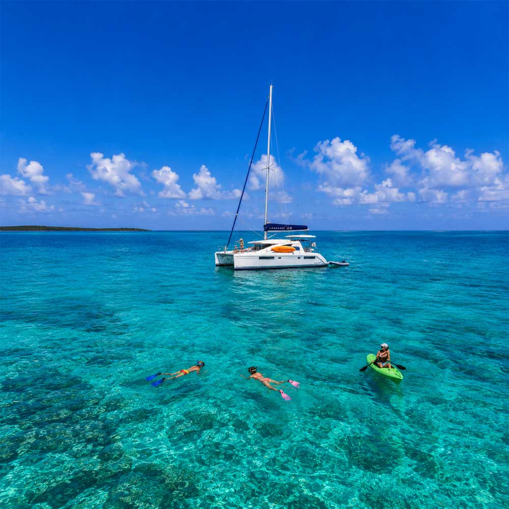 Family-Sailing-Belize - Authentic Travel Belize Belize sailing vacations with a luxury catamaran, snorkeling family, and kayaking adventure over the crystal-clear waters of the Belize Barrier Reef.