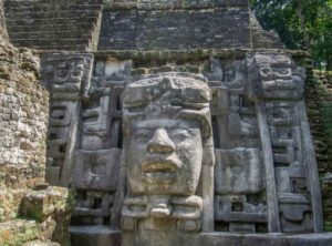 Lamanai-Mask - Authentic Travel Belize Lamanai Maya ruins near Orange Walk Belize. This picture exposes public art through masks in the buildings
