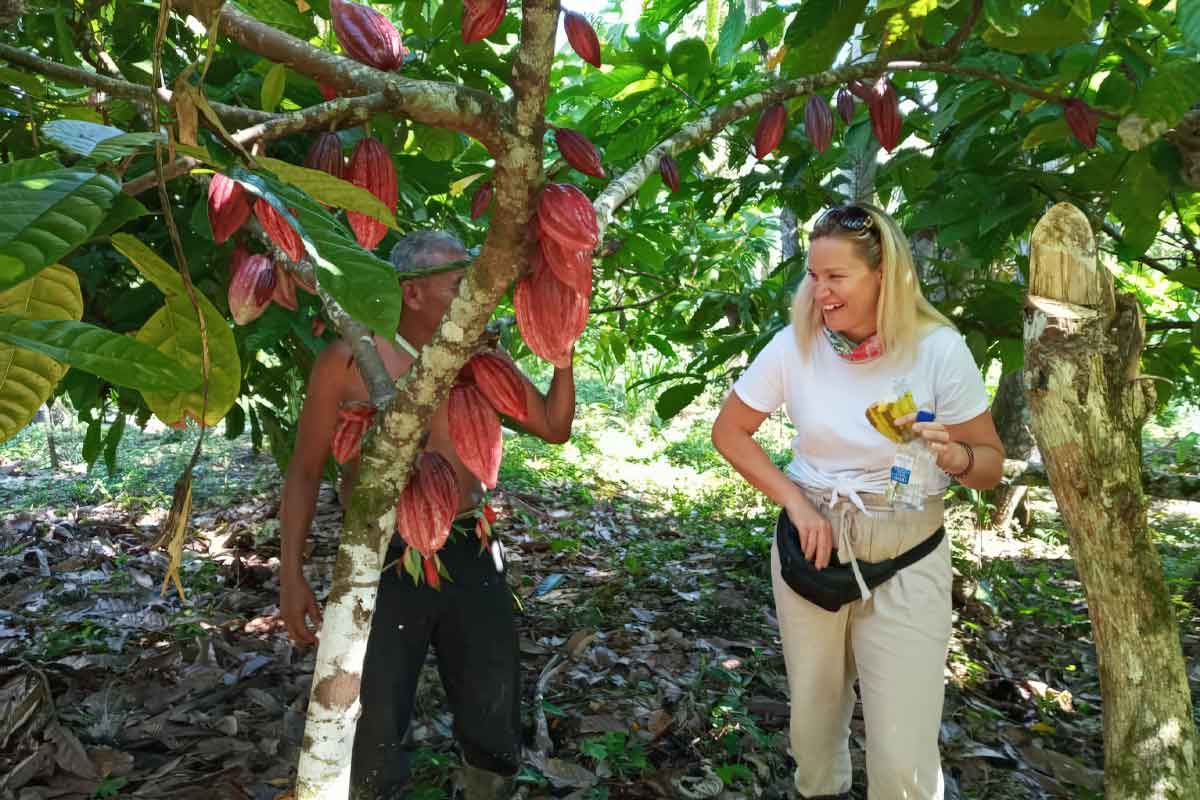 Cultural-Travel - Authentic Travel Belize Woman learning about cacao from a Belize Maya farmer, highlighting cultural connection and hands-on discovery through Belize travel styles.