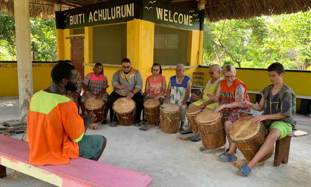 Family-Travel-Belize - Authentic Travel Belize Belize Family Vacations with a mother and young boy enjoying a respectful Garifuna drumming session in Hopkins, Belize.