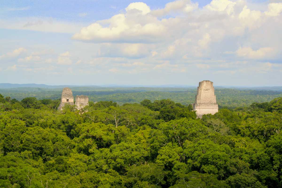 Guatemala-&-Belize-Private-Journeys - Authentic Travel Belize Tikal’s main temples rising above the tropical rainforest canopy, illustrating the heritage and regional depth of Guatemala & Belize Private Journeys.