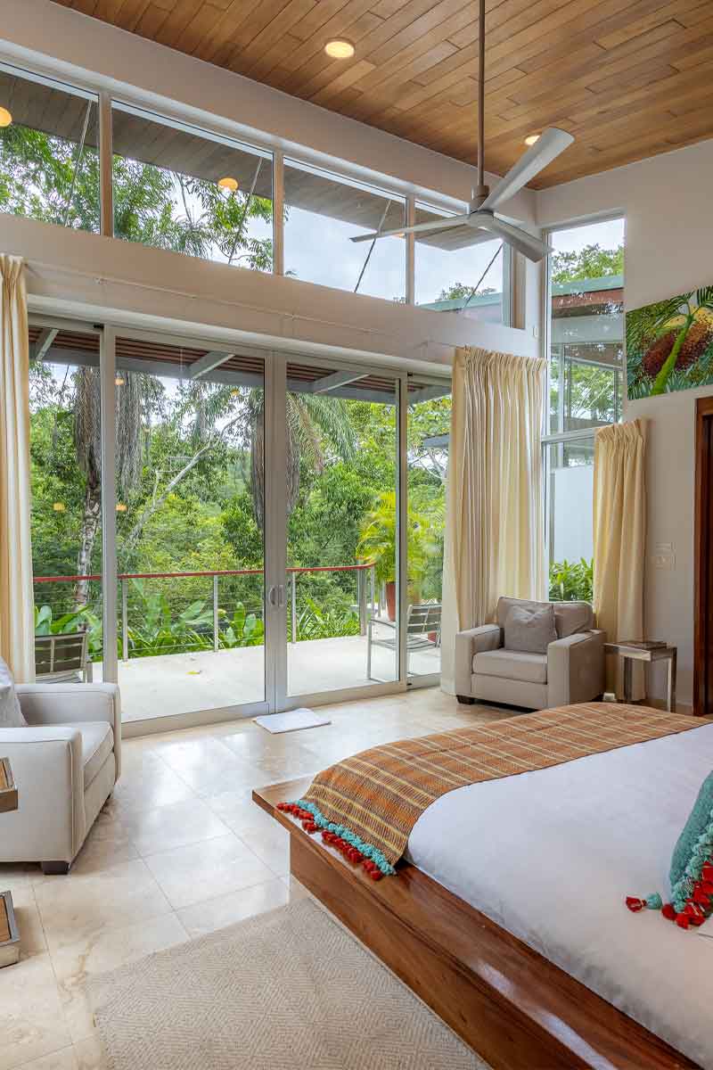 Jungle-View-Room - Authentic Travel Belize Boutique jungle-view room in Belize with floor-to-ceiling windows, natural light, and forest views for Belize luxury and boutique travel.